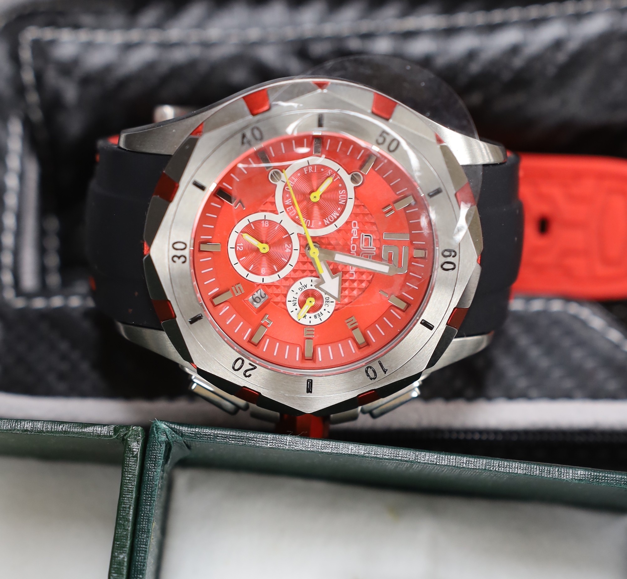 A gentleman's modern stainless steel Delorean automatic calendar wrist watch, with red face and three subsidiary dials, together with three assorted modern MG motors quartz wrist watches.